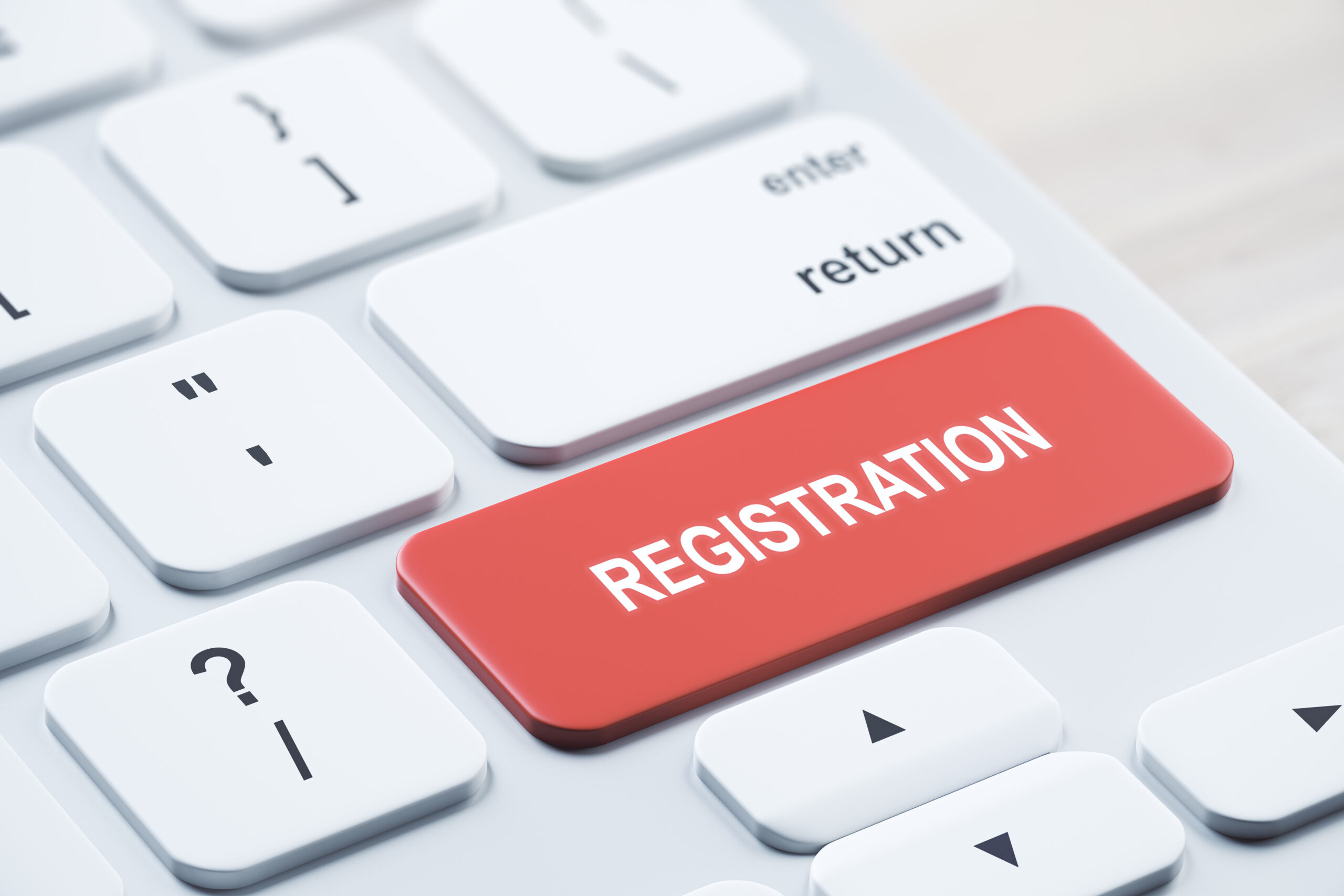 Close up of red registration button on white keyboard placed on blurry wooden desktop. concept. 3D Rendering.